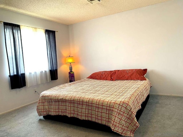 carpeted bedroom featuring a textured ceiling