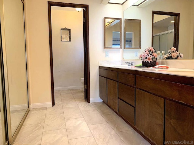 bathroom with walk in shower, vanity, toilet, and tile patterned floors