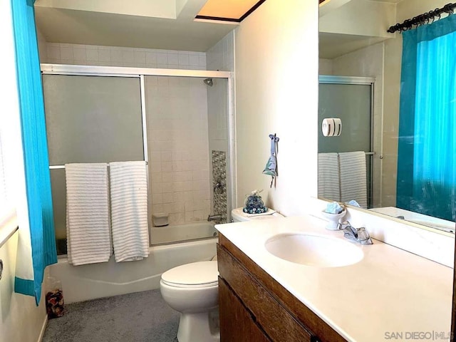 full bathroom with combined bath / shower with glass door, vanity, and toilet