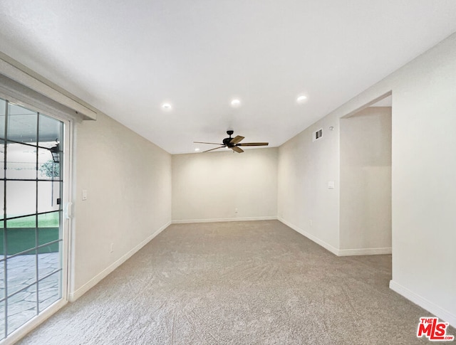 carpeted spare room featuring ceiling fan