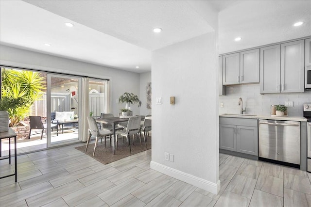 kitchen featuring tasteful backsplash, sink, gray cabinets, and appliances with stainless steel finishes