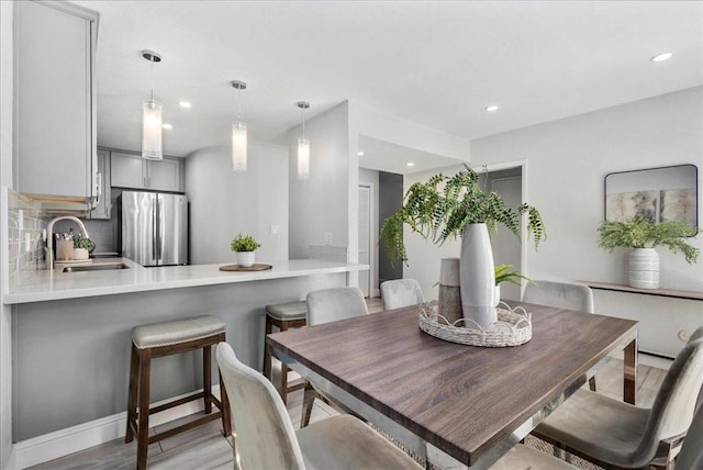 dining space featuring sink and light hardwood / wood-style floors