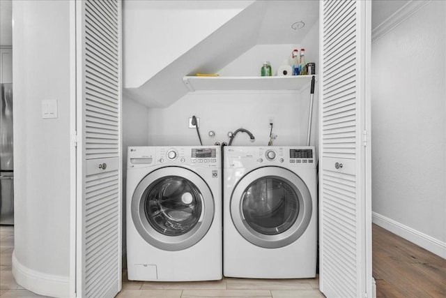 washroom with washer and dryer and light hardwood / wood-style flooring