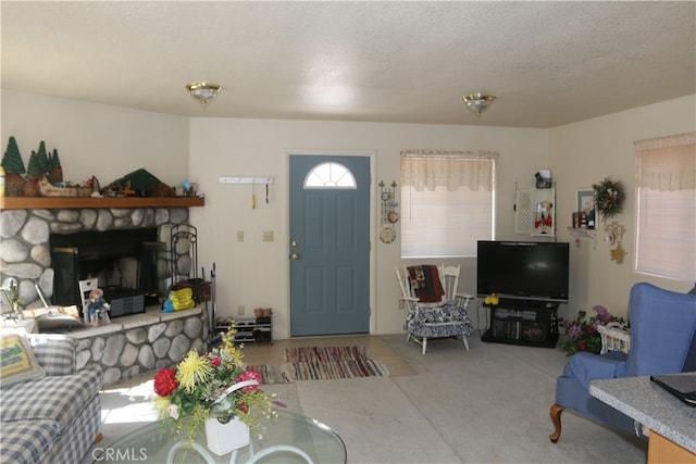 living room featuring a textured ceiling, carpet floors, and a fireplace