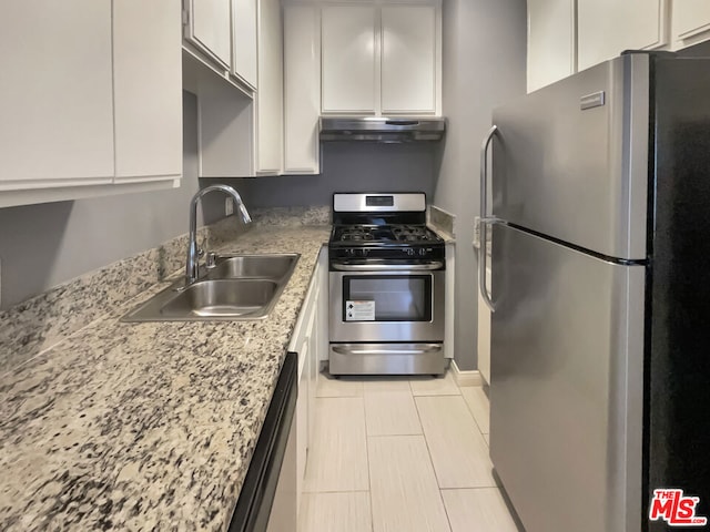 kitchen with white cabinets, light stone counters, appliances with stainless steel finishes, and sink