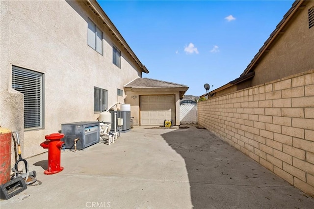 view of home's exterior with a gate, fence, a patio, and stucco siding