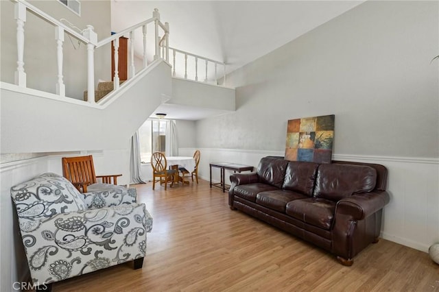 living room featuring stairs, wood finished floors, and a towering ceiling