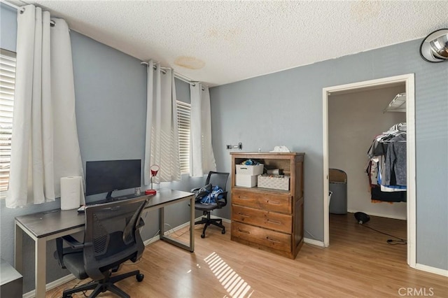 office space with a textured ceiling, wood finished floors, and baseboards