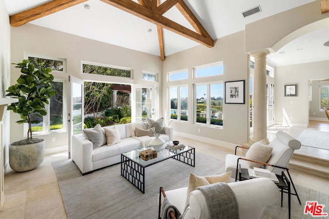 tiled living room featuring decorative columns, a healthy amount of sunlight, high vaulted ceiling, and beamed ceiling