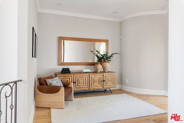 sitting room with wood-type flooring and ornamental molding