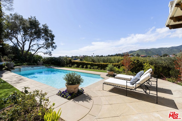 view of swimming pool featuring a patio and a mountain view