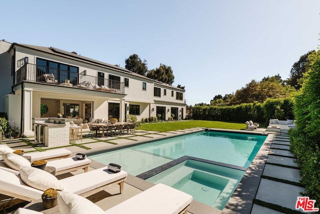 view of pool with an in ground hot tub, a yard, exterior bar, and a patio