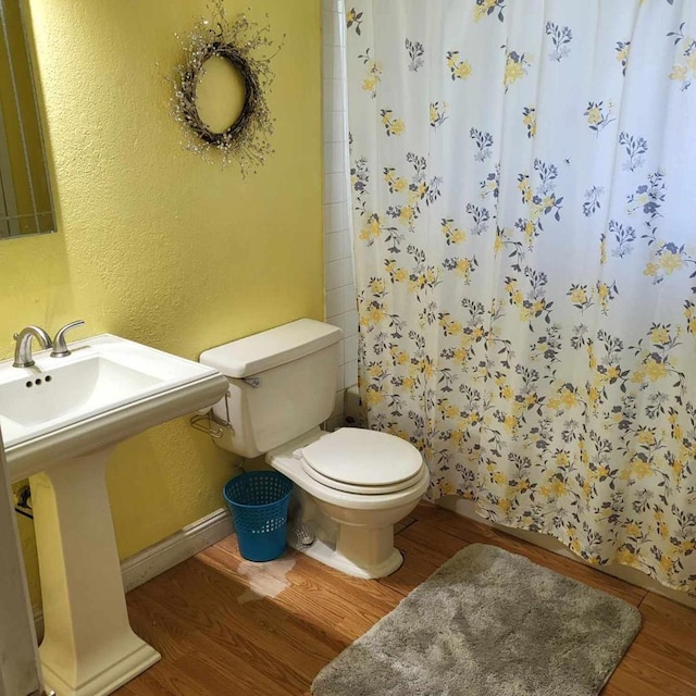 bathroom with toilet, a shower with curtain, wood-type flooring, and sink