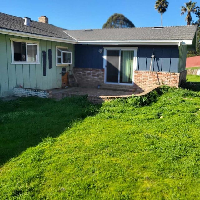 back of property with a yard and a patio area