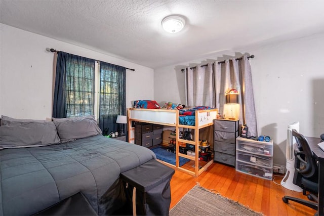 bedroom featuring a textured ceiling and hardwood / wood-style flooring