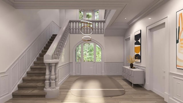 entryway with crown molding, a wealth of natural light, and light hardwood / wood-style flooring