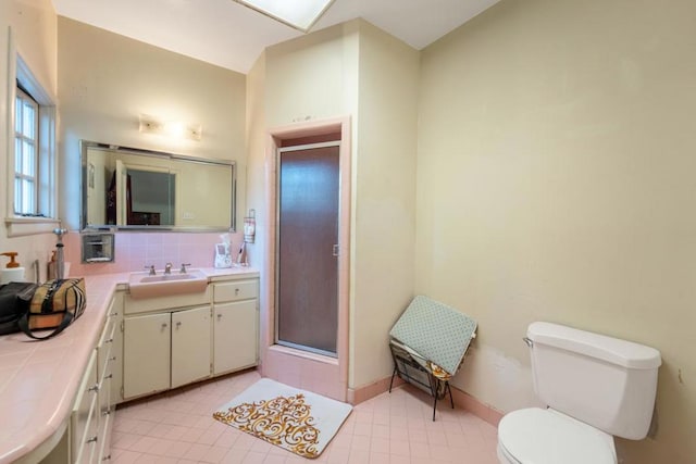 bathroom with decorative backsplash, vanity, toilet, and a shower with door