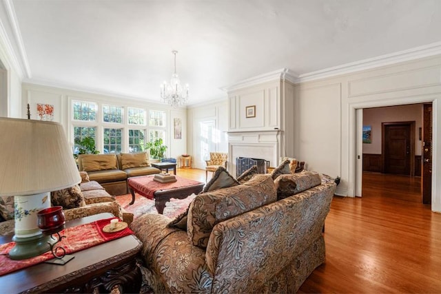 living room featuring hardwood / wood-style flooring, an inviting chandelier, and crown molding