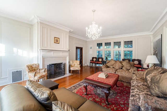 living room with hardwood / wood-style floors, ornamental molding, and a chandelier