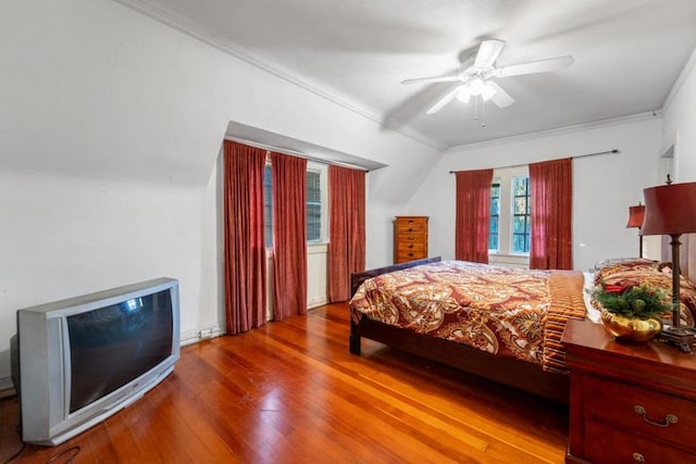 bedroom with hardwood / wood-style floors, vaulted ceiling, ceiling fan, and ornamental molding