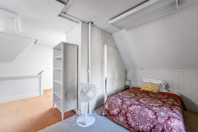 carpeted bedroom with lofted ceiling and wooden walls