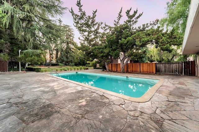 pool at dusk with a patio