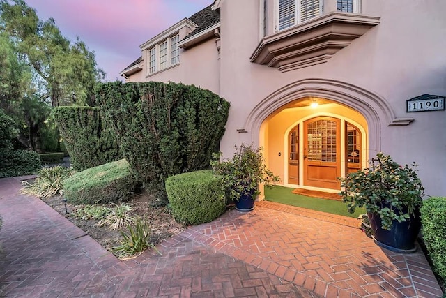 exterior entry at dusk featuring a patio