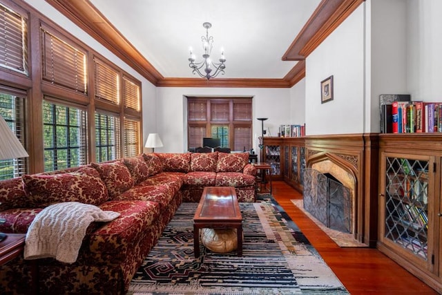 living room featuring hardwood / wood-style flooring, crown molding, and a chandelier