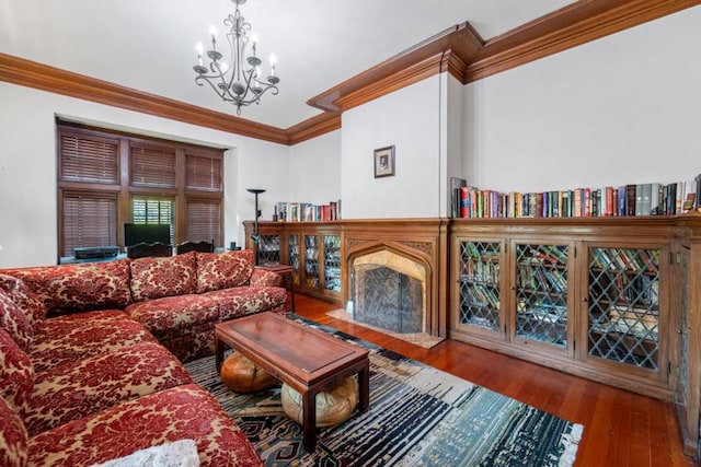 living room featuring a notable chandelier, wood-type flooring, and crown molding