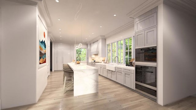 kitchen featuring a center island, hanging light fixtures, a kitchen breakfast bar, light hardwood / wood-style flooring, and custom exhaust hood