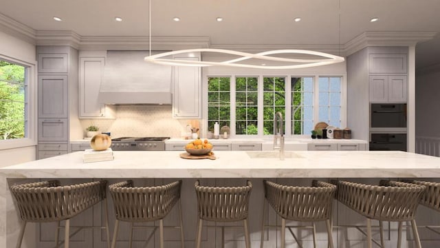 kitchen with a kitchen breakfast bar, backsplash, crown molding, sink, and wall chimney range hood