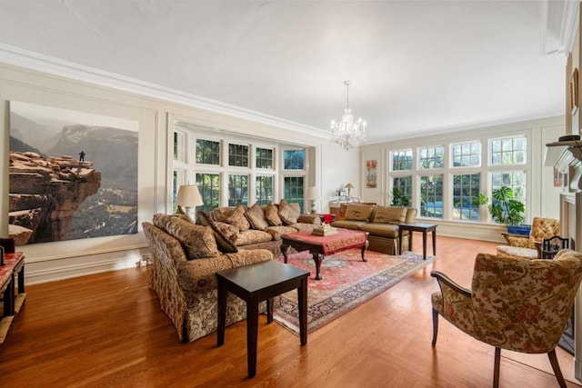 living room featuring crown molding, hardwood / wood-style flooring, and an inviting chandelier