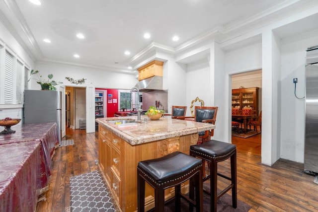 kitchen with a center island with sink, dark hardwood / wood-style floors, and ornamental molding