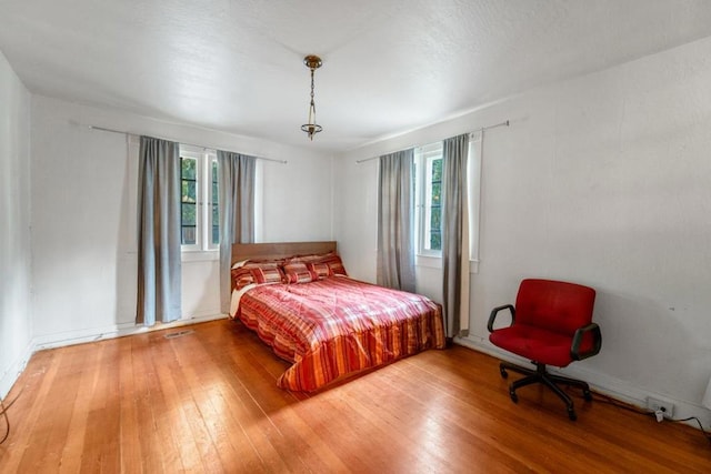 bedroom featuring multiple windows and hardwood / wood-style floors