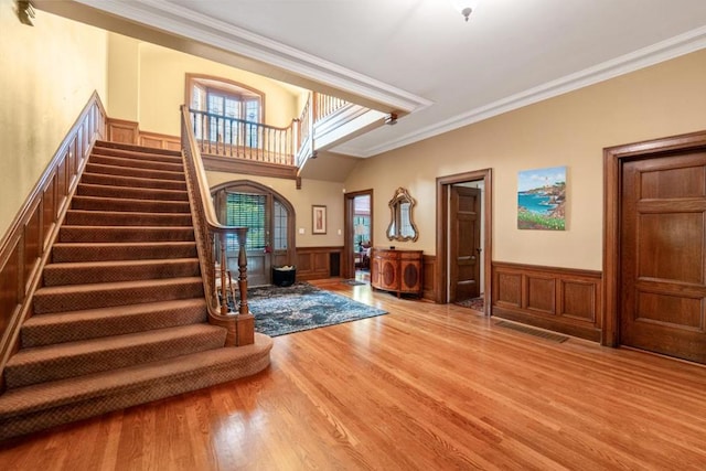 entrance foyer featuring crown molding and wood-type flooring