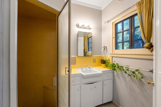 bathroom with tasteful backsplash, crown molding, and vanity