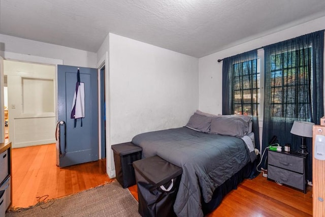 bedroom featuring wood-type flooring and a textured ceiling