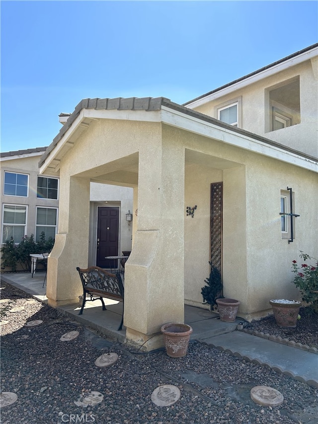 view of exterior entry with a patio area