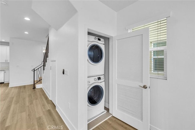 laundry area with stacked washer / dryer and light hardwood / wood-style floors