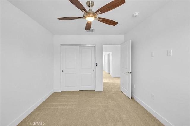 spare room featuring light colored carpet and ceiling fan