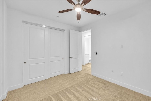 unfurnished bedroom with light colored carpet, ceiling fan, and a closet