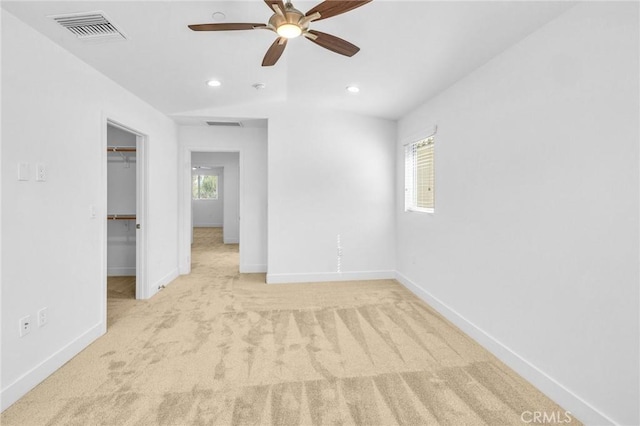 unfurnished room featuring a wealth of natural light, light colored carpet, and ceiling fan