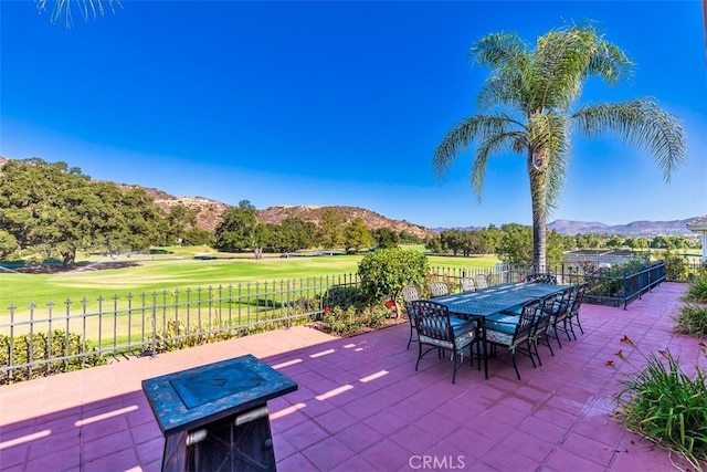 view of patio / terrace with a mountain view, outdoor dining area, and a fenced backyard