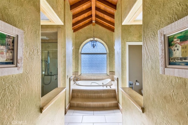 bathroom with tile patterned flooring, a shower stall, vaulted ceiling with beams, a textured wall, and a bath