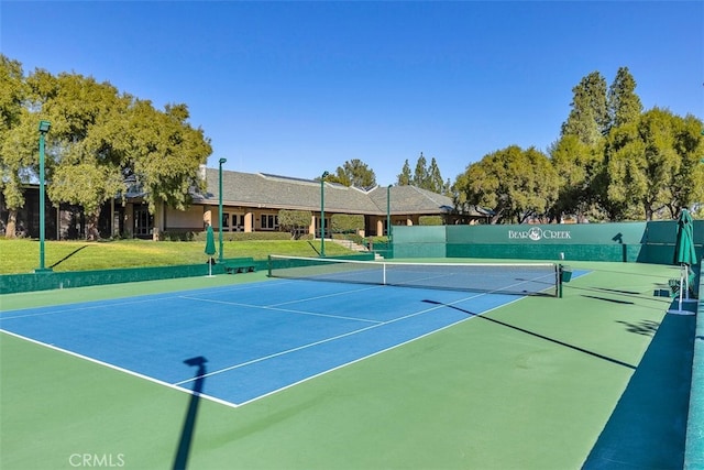 view of sport court featuring a yard and fence