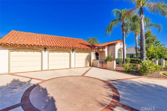 mediterranean / spanish-style home with a gate, stucco siding, a tile roof, and fence