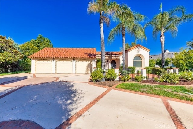 mediterranean / spanish-style home featuring stucco siding, fence, concrete driveway, and a tile roof