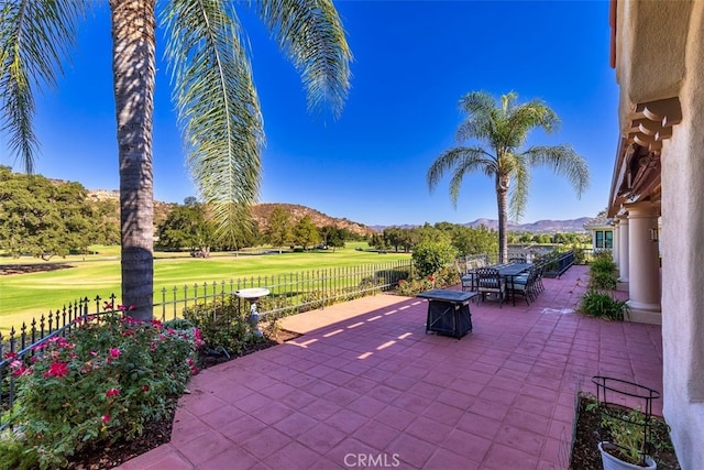 view of patio / terrace featuring a mountain view, fence, and an outdoor fire pit