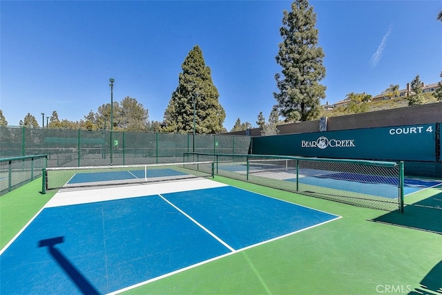 view of tennis court with fence