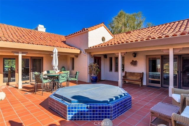 view of patio with outdoor dining space and a covered hot tub